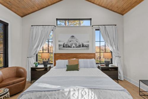a bedroom with a large bed and two windows at Highland House in Banner Elk