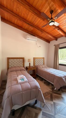 two beds in a bedroom with a wooden ceiling at Complejo Sol y Sombra in San Javier