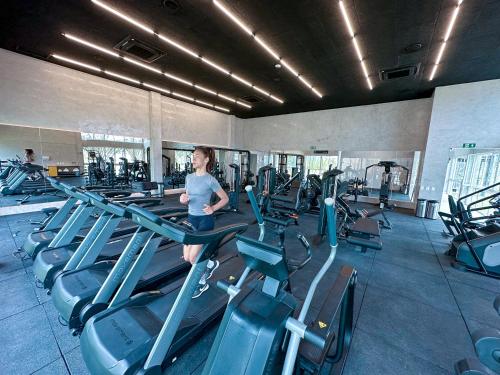 a woman running on a treadmill in a gym at Japaratinga Lounge Resort - All Inclusive in Japaratinga