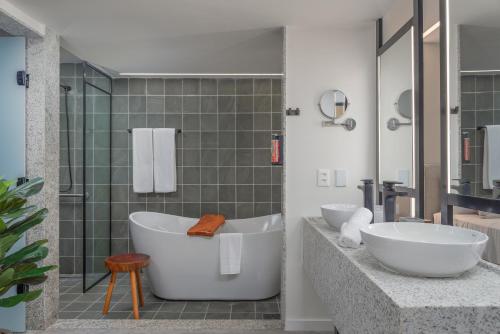 a bathroom with two sinks and a bath tub at Japaratinga Lounge Resort - All Inclusive in Japaratinga