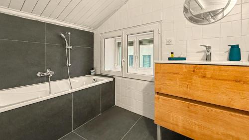 a bathroom with a bath tub and a sink at Le Duplex in Valence