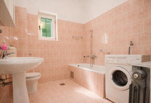 a bathroom with a toilet sink and a washing machine at Apartments in Turanj 150 meters from the sea - By TA Leut Agency in Turanj