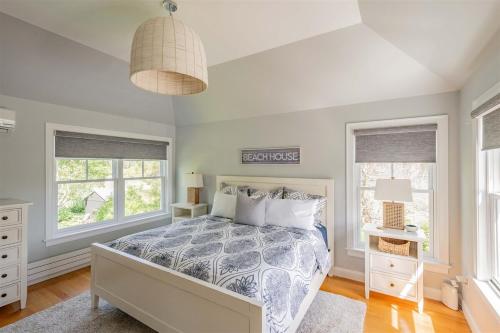 a bedroom with a bed and two windows at Starboard in Kennebunk
