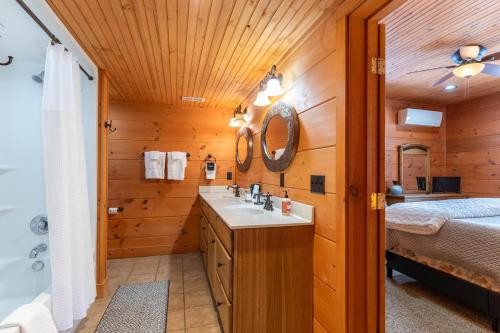a bathroom with a sink and a bed and a mirror at Rosey Outlook in Boone