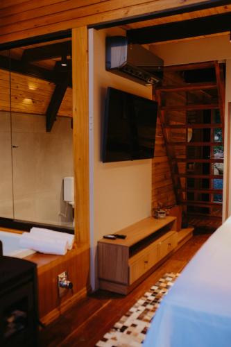 a bedroom with two bunk beds and a television at Canaã Cabanas in Mariópolis