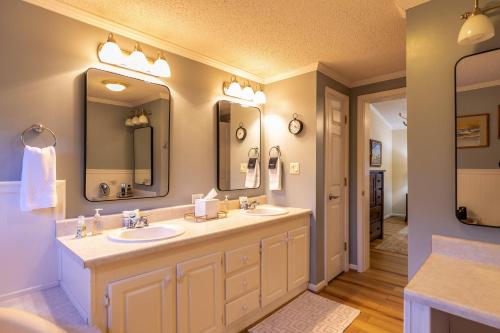 a bathroom with two sinks and two mirrors at Our Happy Nest in Boone