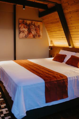 a bedroom with a large bed with white sheets at Canaã Cabanas in Mariópolis