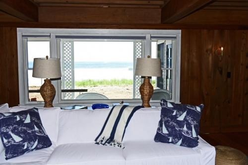 a white couch in a room with a view of the beach at Nautilus Beach House in Kennebunk