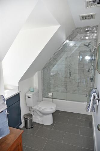 a bathroom with a toilet and a glass shower at Nautilus Beach House in Kennebunk