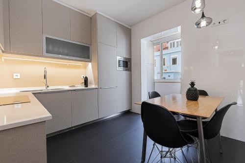 a kitchen with a wooden table and black chairs at Cortes Apartment in Lisbon Historic Neighborhood in Lisbon