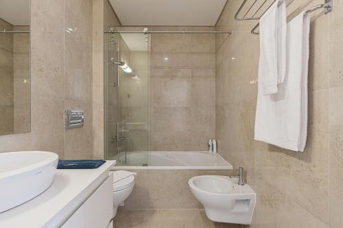 a bathroom with a sink and a toilet and a bath tub at Cortes Apartment in Lisbon Historic Neighborhood in Lisbon