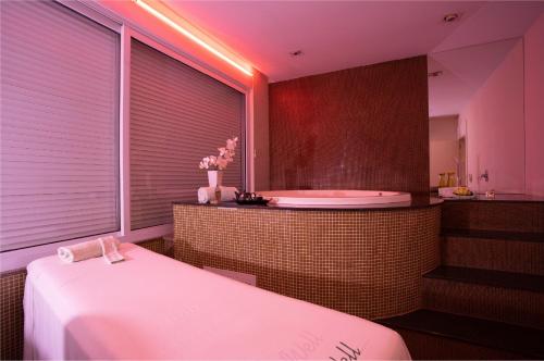 a bathroom with a tub and a sink and a bath tub at Recanto Cataratas - Thermas, Resort e Convention in Foz do Iguaçu