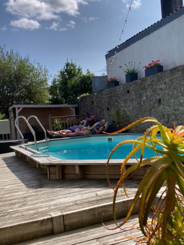a pool with people lounging around in a building at Les chambres d'ACCO té in Saint-Nicolas-du-Pélem