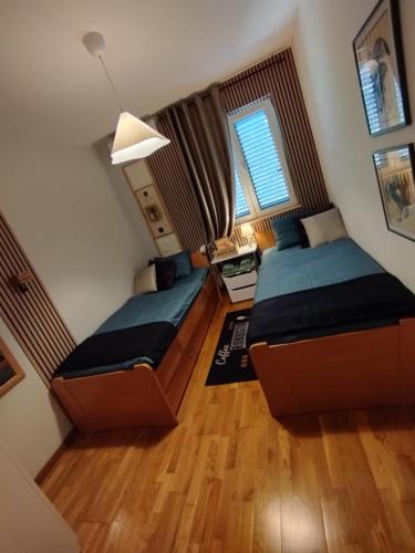 two beds in a small room with wooden floors at La vita e bella in Prčanj