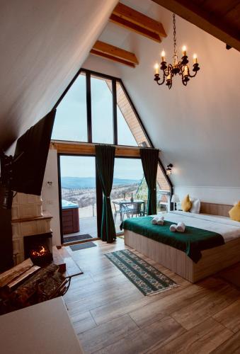 ein Schlafzimmer mit einem großen Bett und einem Kamin in der Unterkunft A-Frame Prislop,Hațeg in Silvaşu de Sus