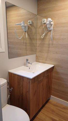 a bathroom with a sink and a mirror and a toilet at Camping-Bungalows Altomira in Navajas