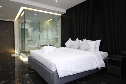 a bedroom with a large white bed and a shower at Stylish Condo Near Nai Harn Beach Full Facilities Utopia M720 in Rawai Beach