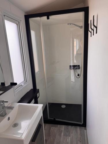 a bathroom with a shower and a white sink at mobil home spacieux climatisé sur camping sol a gogo in Saint-Hilaire-de-Riez