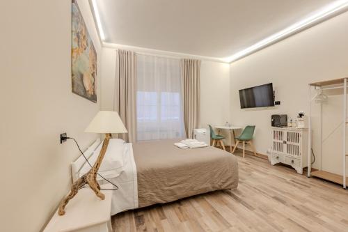 a hotel room with a bed and a table with chairs at Le Colonne Di San Luca Affittacamere in Genoa