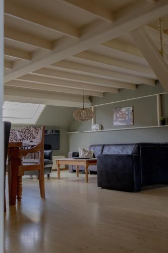 a living room with a couch and a table at Bij Ons Achter in Biggekerke