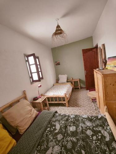 a bedroom with two beds and a window at Hippie Chic - Room La Dune in Sidi Kaouki