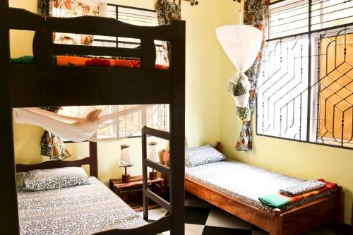 two bunk beds in a room with a window at Rafiki Backpackers & Guesthouse in Moshi