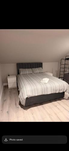 a bedroom with a large bed with a wooden floor at The Arch apartment in Bangor