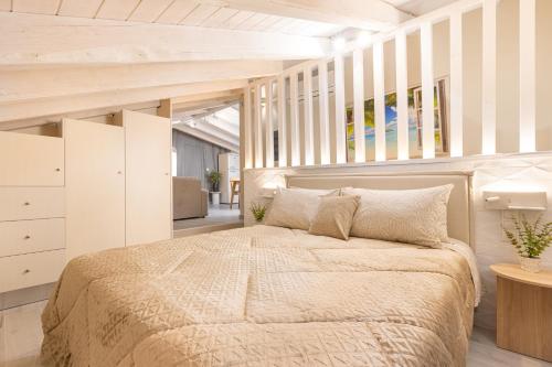 a bedroom with a large bed and white walls at Pythagoreio Blue Street Upper Floor Apartment in Pythagoreio