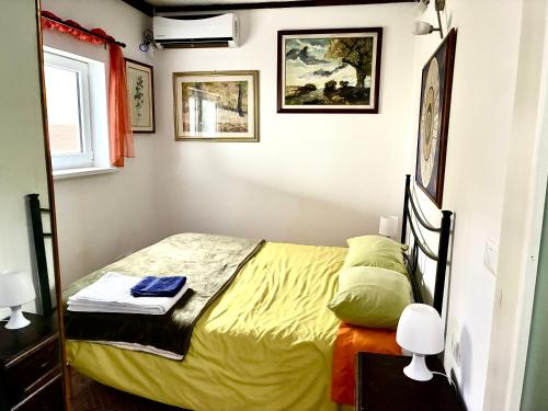 a small bedroom with a bed with yellow sheets at Su da noi in San Dorligo della Valle