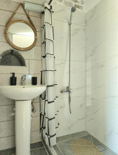 a bathroom with a shower and a sink and a mirror at Rigas stone tower east Mani 2 in Agriliá