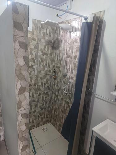 a shower with a glass door in a bathroom at Chalé Garças in Chapada dos Guimarães