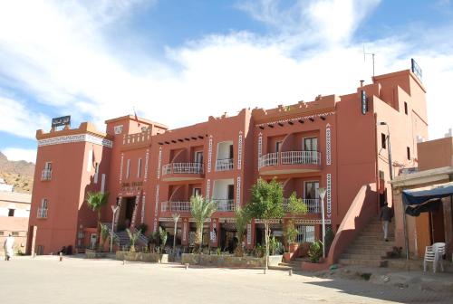 un edificio rosso con scale di fronte di Hotel Salama STE SAL- AMA SUD SARL AU a Tafraout