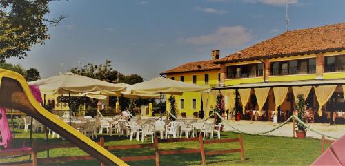 a group of tables and chairs in front of a yellow building at Alloggi e Trattoria Agli Alberoni in Brussa