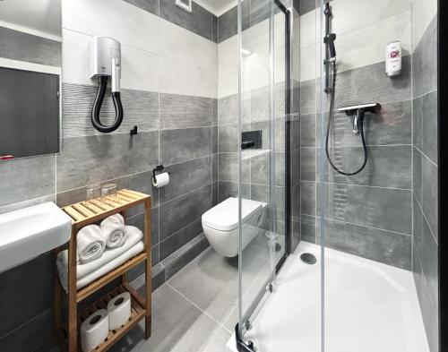 a bathroom with a shower and a toilet and a sink at Wellness penzion a restaurace U Gigantu in Pilsen