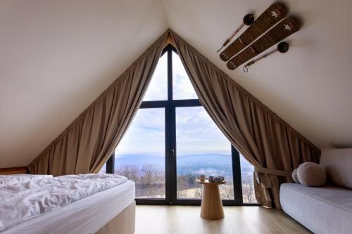 a bedroom with a bed and a large window at Góry i Chmury in Duszniki Zdrój