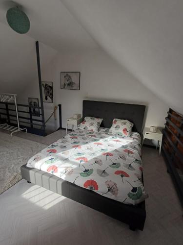 a bedroom with a bed with a comforter with umbrellas at Une parenthése à la campagne in Cirey