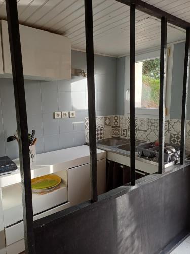 a kitchen with white counters and a sink at Une parenthése à la campagne in Cirey