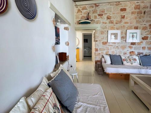 a living room with a couch and a stone wall at Agnanti Beach House in Patmos