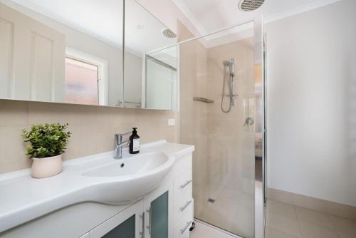 a white bathroom with a sink and a shower at Parkside Breeze in Rosebud in Rosebud