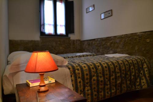 a lamp on a table next to two beds at Agriturismo Nestore in Nestore