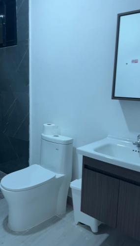 a bathroom with a white toilet and a sink at RUKA Hotel in Punta Cana
