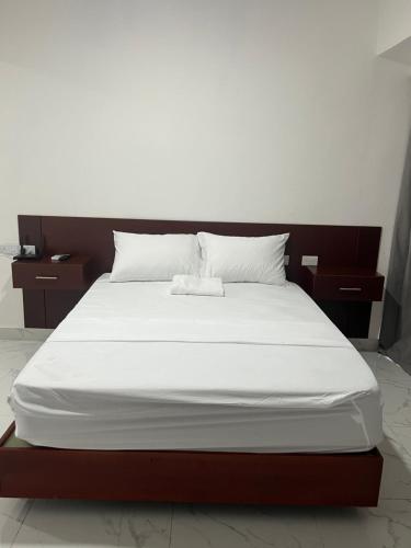 a large bed with white sheets and pillows on it at RUKA Hotel in Punta Cana