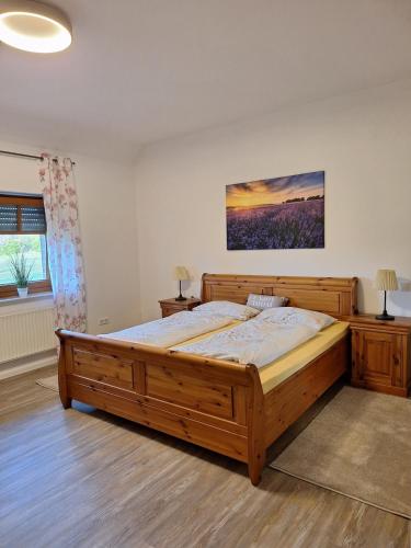 a bedroom with a large wooden bed in a room at Haus mit Seeblick in Fürstenau