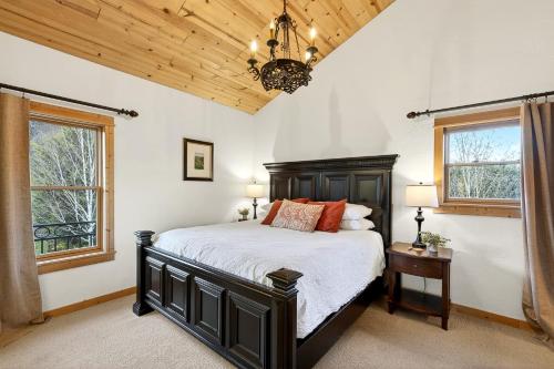 a bedroom with a bed and two windows and a chandelier at Franziska Haus in Dundee