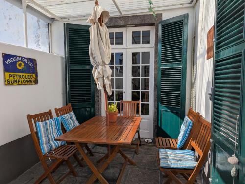a wooden table and chairs on a patio at quarto duplo downtown in Ponta Delgada
