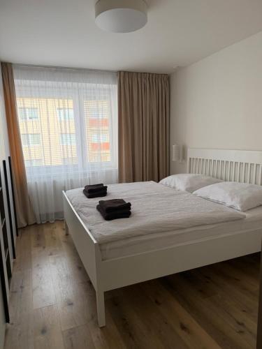 a bedroom with a large white bed in front of a window at 2 izbový moderný byt centrum in Veľký Krtíš