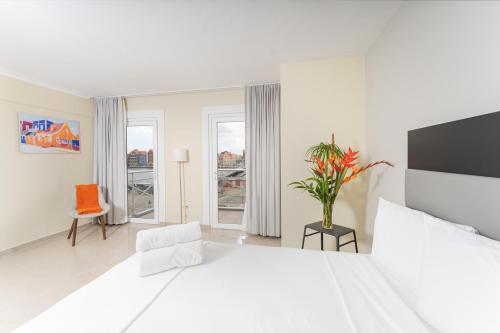 a white bedroom with a large bed and a chair at Brion City Hotel BW Signature Collection in Willemstad