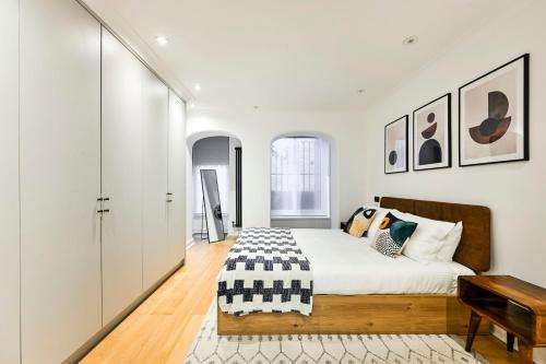 a bedroom with a bed in a white room at The Collection Stays Chelsea in London