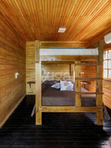 a bedroom with two bunk beds in a wooden cabin at Suite Top – Cyclists' Paradise in Gramado
