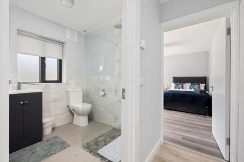 a bathroom with a toilet and a sink and a bed at North Dublin Premier Oasis in Dublin